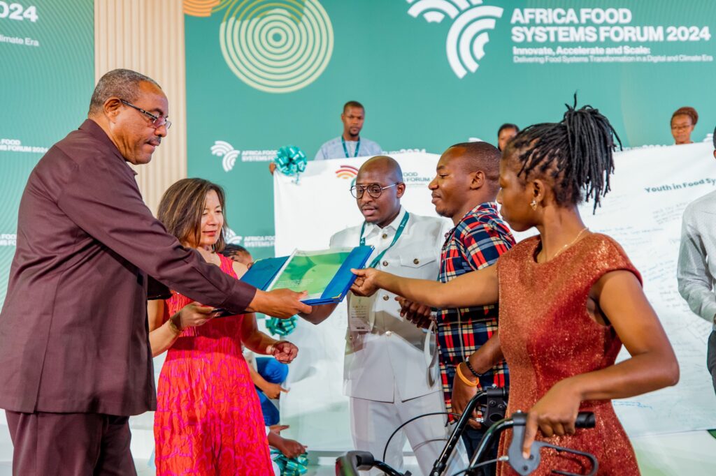 AGRA Board Chair H.E Hailemariam Dessalegn, Mastercard FoundationCEO Reeta Roy, receive a copy of the Kigali Declaration on Food Systems, Policy and Climate Action from differently abled youth from Malawi and Mozambique.